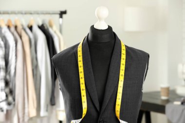 Tamamlanmamış ceketli manken ve terzi dükkanında mezura.