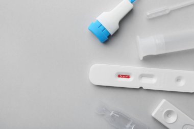 Açık gri zemin üzerinde Covid-19 ekspres test kiti, düz yatıyordu. Metin için boşluk