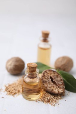 Nutmeg temel yağ ve fındıklar beyaz masada.