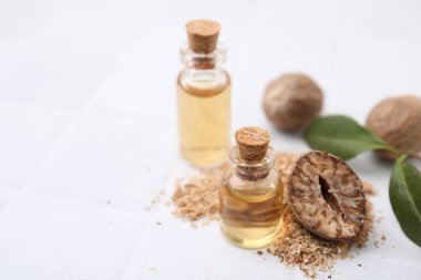 Nutmeg esaslı yağ ve fındıklar beyaz masada. Metin için boşluk