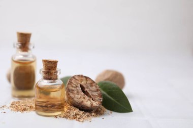 Nutmeg esaslı yağ ve fındıklar beyaz masada. Metin için boşluk