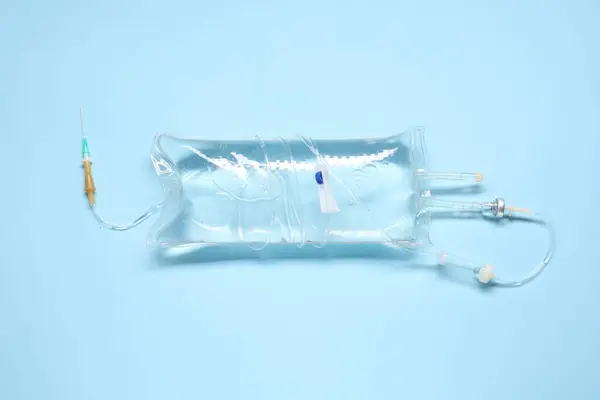IV infusion set on light blue background, top view
