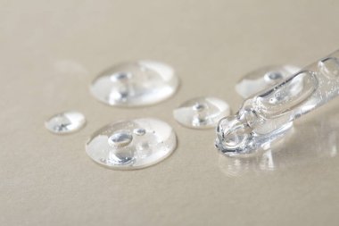 Bej arka planda kozmetik serumlu boru, makro görünüm