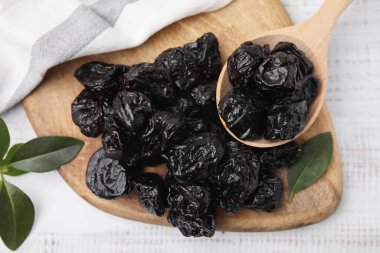 Lezzetli kuru erikli kaşık ve açık ahşap masa üzerinde yeşil yapraklar.