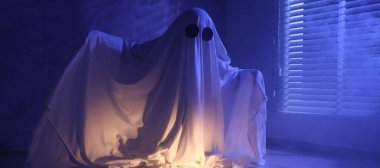 Ürkütücü hayalet. Pencerenin yanında, mavi ışıkla kaplanmış kadın.