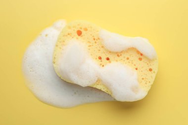 Sarı arka planda köpüklü sünger, üst görünüm