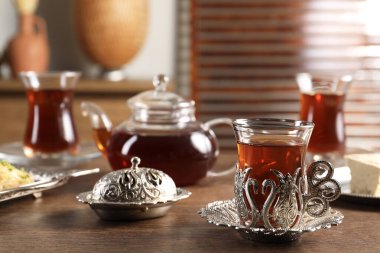 Geleneksel Türk çayı ahşap masaya konmuş klasik çay setinde servis edilir.