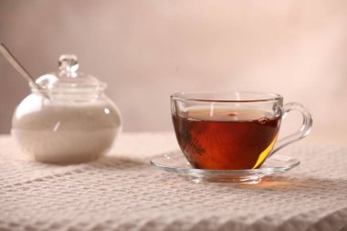 Aromatik çay fincanda, çay tabağında ve masada şeker