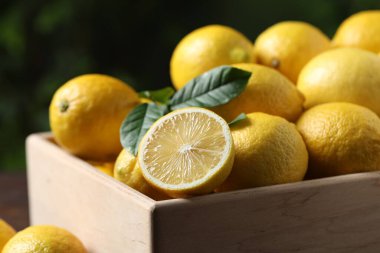 Tahta sandıkta taze limonlar bulanık arka planda, yakın plan