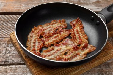 Lezzetli pastırmalar tavada dilimler ahşap masada, yakın plan