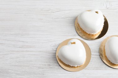 Sevgililer Günü. Lezzetli kalp şekilli kekler beyaz ahşap masada, düz yerde. Metin için boşluk