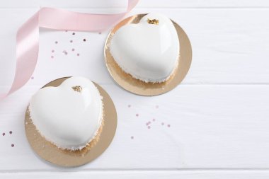 Sevgililer Günü. Lezzetli kalp şeklinde kekler ve beyaz ahşap masa üzerinde konfeti düz bir şekilde yatıyordu. Metin için boşluk