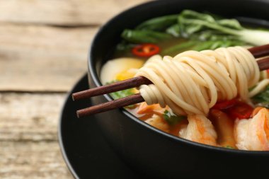 Yemek çubuklarıyla bir kase lezzetli ramen, yakın çekim ve yazı için yer. Erişte çorbası.