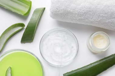 Kozmetik ürünleri ile düz konum ve beyaz arkaplanda aloe yaprakları kesme