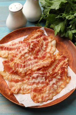 Lezzetli kızarmış domuz pastırması mavi ahşap masada, yakın plan.