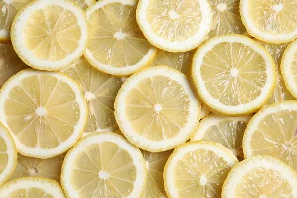 Slices of fresh lemons as background, top view