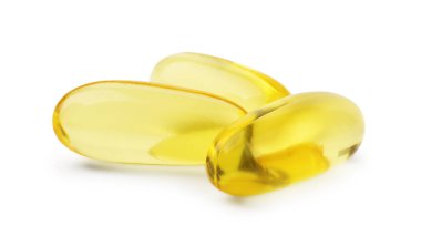 Beyaz üzerine izole edilmiş birçok sarı vitamin kapsülü