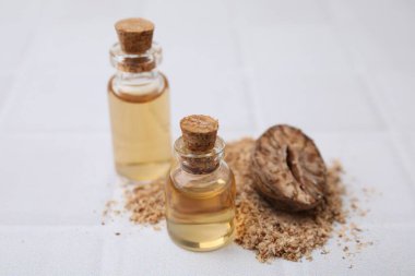 Nutmeg esaslı yağ, beyaz masanın üzerinde yer fıstığı, yakın plan.