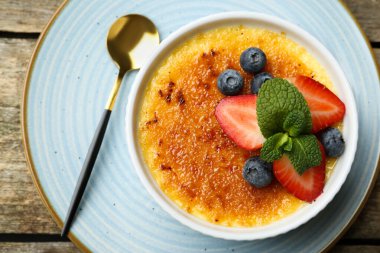 Böğürtlenli ve nane şekerli nefis creme brulee ahşap masada, üst manzara