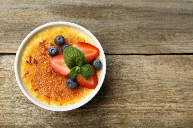 Böğürtlenli nefis creme brulee ve ahşap masada nane şekeri, üst manzara. Metin için boşluk