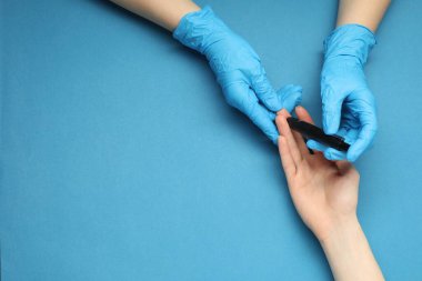 Diyabet. Glikoz testi. Doktor mavi arka planda tükenmez kalem kullanıyor, üst görüş. Metin için boşluk