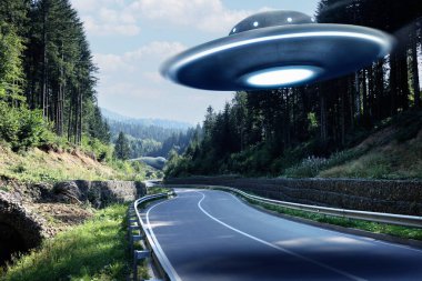 Uzaylı uzay gemisi dağlarda yol üzerinde uçuyor. UFO
