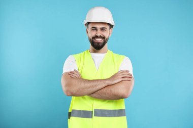 Açık mavi arka planda sabit şapkalı mühendis.