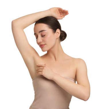 Güzel bir kadın, beyaz arka planda pürüzsüz, temiz bir ciltle koltukaltı gösteriyor.