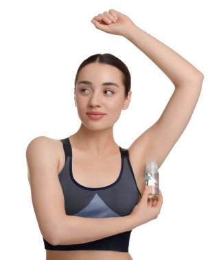 Güzel bir kadın beyaz arka plana deodorant sürüyor.