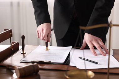 Ofisteki ahşap masada noter damgası belgesi, yakın plan.