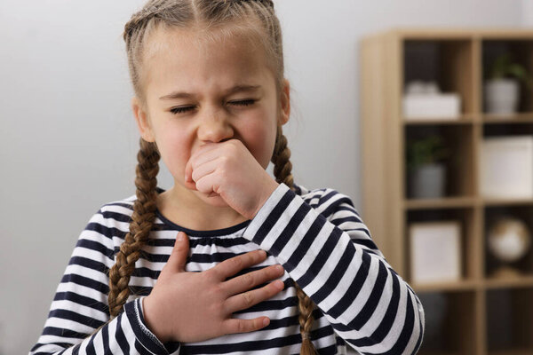 Sick girl coughing at home. Cold symptoms