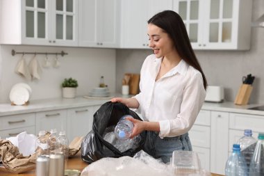 Mutfakta çöpleri ayıran gülümseyen kadın. Metin için boşluk