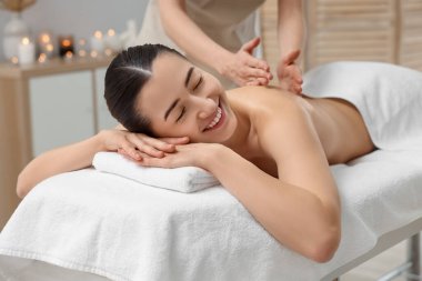 Spa salonundaki kanepede sırt masajı yaptıran kadın.