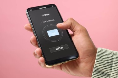 Yeni mesajım var. Pembe arka planda akıllı telefon kullanan adam, yakın plan