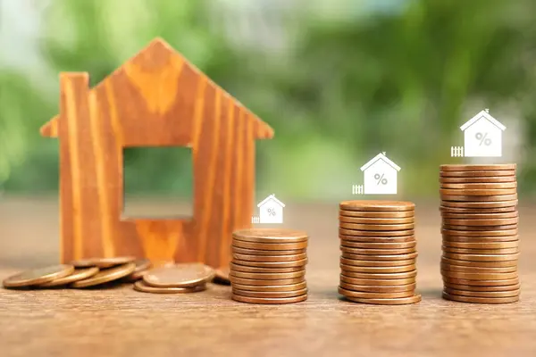 Mortgage rate. Stacked coins, percent signs and wooden model of house
