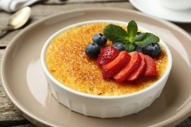 Böğürtlenli ve nane şekerli nefis creme brulee ahşap masada, yakın plan