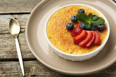 Böğürtlenli ve nane şekerli nefis creme brulee ahşap masada, yakın plan
