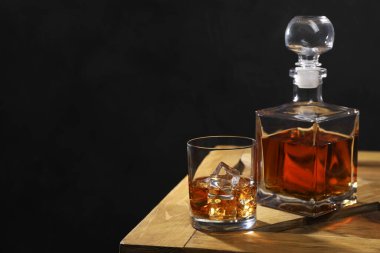 Buzlu viski, cam küplü ve tahta sandıkta siyah arka planda, metin için yer var.