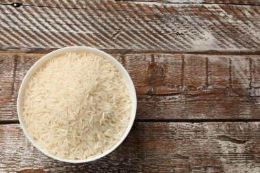 Tabakta çiğ basmati pilavı, ahşap masa, üst manzara. Metin için boşluk