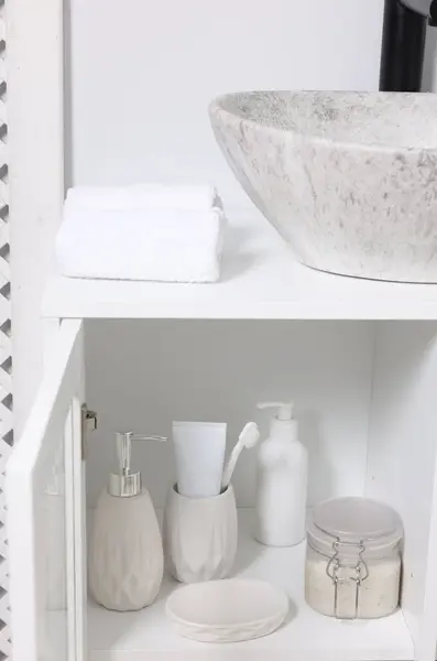 Different personal care products and bath accessories in bathroom vanity