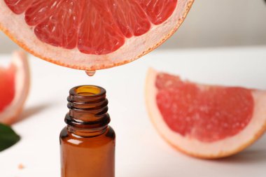 Masada meyve suyundan şişeye greyfurt suyu damlatıyor, yakın plan. Metin için boşluk