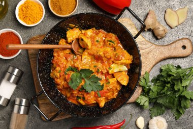 Lezzetli tavuk körisi ve malzemeler gri masada, düz yatıyordu.