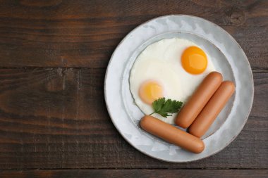 Lezzetli haşlanmış sosisler, sahanın üstünde kızarmış yumurta ve maydanoz. Metin için boşluk