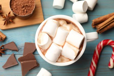 Lezzetli sıcak çikolata, lokum ve açık mavi ahşap masa üzerindeki malzemeler.