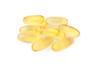 Beyaz üzerine izole edilmiş birçok sarı vitamin kapsülü