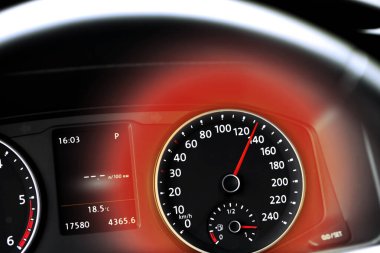 Arabanın gösterge panelindeki hız göstergesi ve etrafındaki kırmızı ışık, yakın çekim