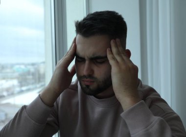 Evdeki pencerenin yanındaki üzgün adamın portresi