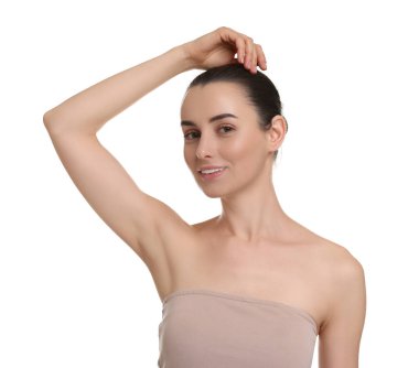 Güzel bir kadın, beyaz arka planda pürüzsüz, temiz bir ciltle koltukaltı gösteriyor.