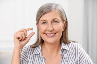 Menopoz, hormon değiştirme terapisi. Evde hapları tutan mutlu kadın.