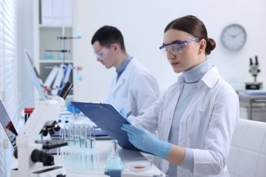 İçeride laboratuvar test formlarıyla çalışan bilim adamları. Tıbbi araştırma